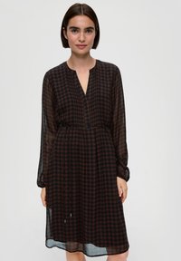 Zwarte en roestkleurige gemarmerde jurk met lange mouwen, V-hals en elastische taille. Lichte, transparante stof met een vloeiende silhouette.