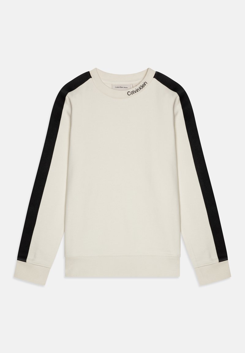 Sudadera crema con largas franjas negras en los hombros, puños acanalados y cuello redondo. Presenta un sutil logo en el cuello. Textura de tela suave.