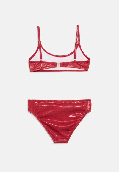 Bikini deux pièces rouge brillant avec bretelles réglables et fermeture au dos sur le haut, assorti à un bas de bikini taille haute.
