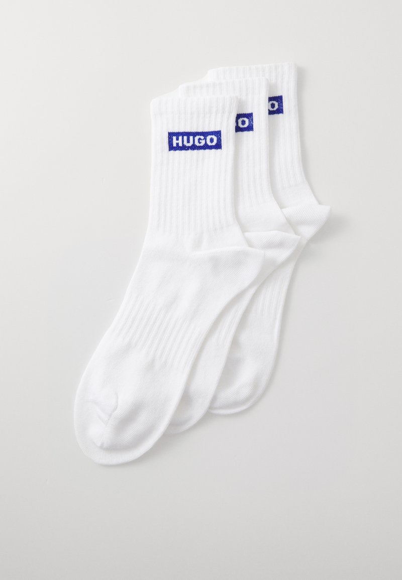 Weiße gerippte Socken mit blauem "HUGO"-Logo am Bündchen. Weiches Material, Standard Crew-Länge und nahtloses Zehendesign. Set mit drei Paaren.