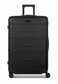 Valigia nera con guscio rigido e finitura testurizzata. Dotata di manico telescopico e quattro ruote per la mobilità. Tre scanalature orizzontali sulla parte anteriore.