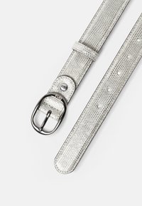 Cinturón de cuero texturizado plateado con hebilla plateada redondeada y múltiples orificios de ajuste sobre un fondo blanco liso.