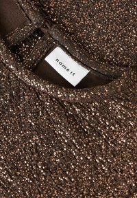 Donkerbruine kleding met metallic koperkleurige spikkels, close-up van de halslijn en wit merketiket "name it" dat binnenin is genaaid.