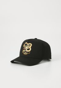 Casquette de baseball noire en coton avec un design structuré. Dotée d'un logo brodé en or et blanc représentant un serpent et du texte à l'avant.