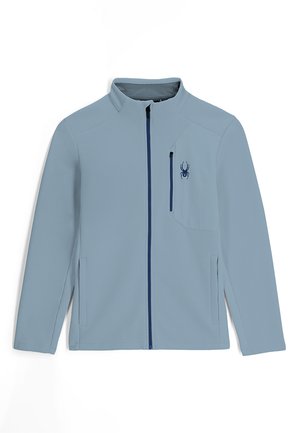 Lichtblauwe zip-up jack met ribbelstructuur, een klein borstzakje en een marineblauwe rits. Bevat een spinnenlogo aan de linkerkant.