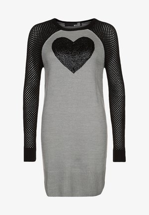 Robe en tricot grise avec des manches en résille noires, présentant un grand motif de cœur en sequins noirs sur le devant. Ourlet côtelé en bas.
