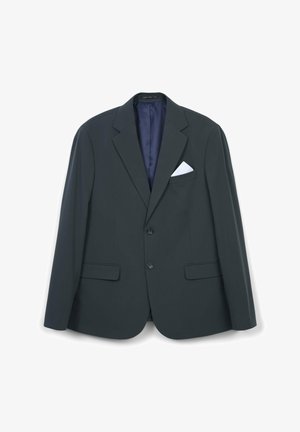 Giacca su misura verde scuro con rever a rondine, due tasche anteriori e un fazzoletto bianco nel taschino. Tessuto liscio e chiusura a un bottone.