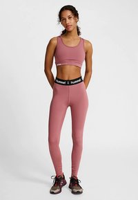 Sportbehå i hallonrosa kombinerad med matchande högmidjade leggings. Behån har en liten logga och leggingsen har ett svart midjeband med varumärke.
