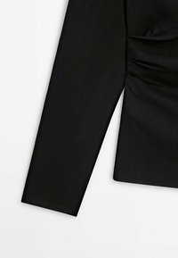 Black long-sleeve top with a textured finish, featuring a gathered design on the side and a straight-cut sleeve.