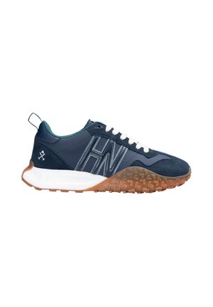 Zapatilla deportiva azul marino con cordones blancos, entresuela blanca, suela marrón texturizada y logotipo bordado en el lateral y en la lengüeta del talón.