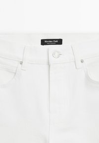 Ceinture d'un jean en denim blanc montrant un bouton, des passants de ceinture, des poches avant et une étiquette noire Massimo Dutti indiquant Made in Morocco.