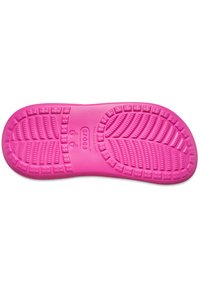 Suela de goma rosa con patrones de agarre texturizados y acentos elevados, diseñada para la comodidad y la tracción. Presenta el logo en el centro.