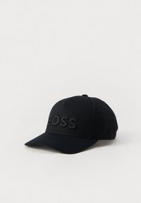 Melna samta cepure ar izliekto malu, uz kuras priekšpuses ir izsistais logo "BOSS", veidota ar strukturētu kroni un regulējamu jostu.