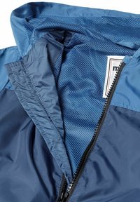 Chaqueta de marina con un exterior suave y forro de malla. Cuenta con una cremallera negra y una etiqueta de la marca visible en el área del cuello.
