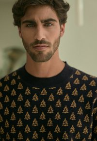 Marineblaues Sweatshirt mit einem wiederholten goldenen Baum-Muster. Rundhalsausschnitt und weiche Textur, entworfen für eine bequeme Passform.