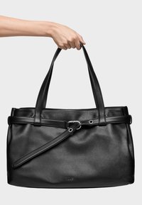 Czarna skórzana torba na ramię o eleganckim designie, solidne uchwyty oraz odpinany pasek. Zawiera ozdobę w postaci paska i wytłoczone logo z przodu.