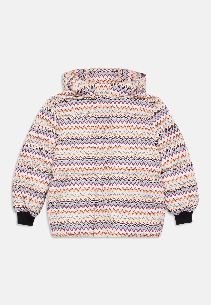 Uzpūšamā jaka ar daudzkrāsainu zigzaga rakstu, pievienota kapuce un melnas elastīgas aproces, izklāta uz baltas virsmas.