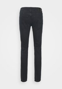 Jeans de corte slim, de lavado oscuro, hechos de denim. Cuenta con una cintura de altura media, diseño de cinco bolsillos y costuras sutiles en los bolsillos traseros.