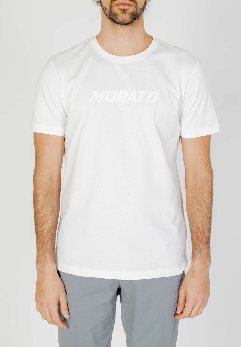 Camiseta de algodón blanca con mangas cortas. Presenta un logo en contraste "MORATO" en un color destacado y ligeramente en relieve en el pecho.