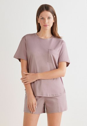 Ljuslila t-shirt med korta ärmar och ficka, tillverkad av mjukt tyg. Den har en avslappnad passform och nederkant vid höften, kombinerad med matchande shorts.