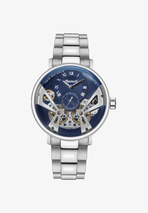 Zilveren roestvrijstalen polshorloge met een blauwe textuur wijzerplaat. Voorzien van een zichtbaar uurwerk, uurmarkeringen en twee sub-dials. Automatisch mechanisme.