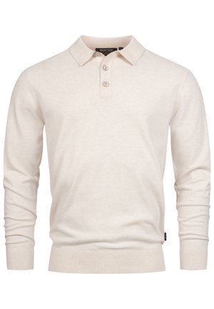 Vaaleanbeige pitkähihaine pikeepaita, joka on valmistettu pehmeästä kankaasta. Paidassa on ribbauskaulus, kolme nappia edessä ja slim fit -helma.