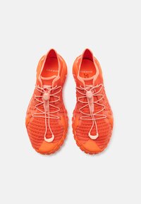 Oransje treningssko med teksturert mesh-overdel, integrerte snørebånd og polstret såle. Lettvektsdesign med et robust og fargerikt utseende.