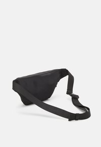 Marsupio in tessuto nero a forma triangolare, dotato di una larga cinturino regolabile e chiusura con zip. Texture liscia e design minimal.