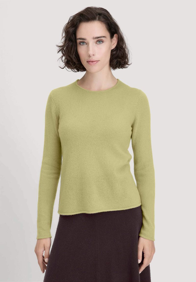 Langarmpullover aus hellgrünem Strickstoff mit rundem Ausschnitt, weichem Griff und lockerer Passform, kombiniert mit einem dunkelbraunen Rock.