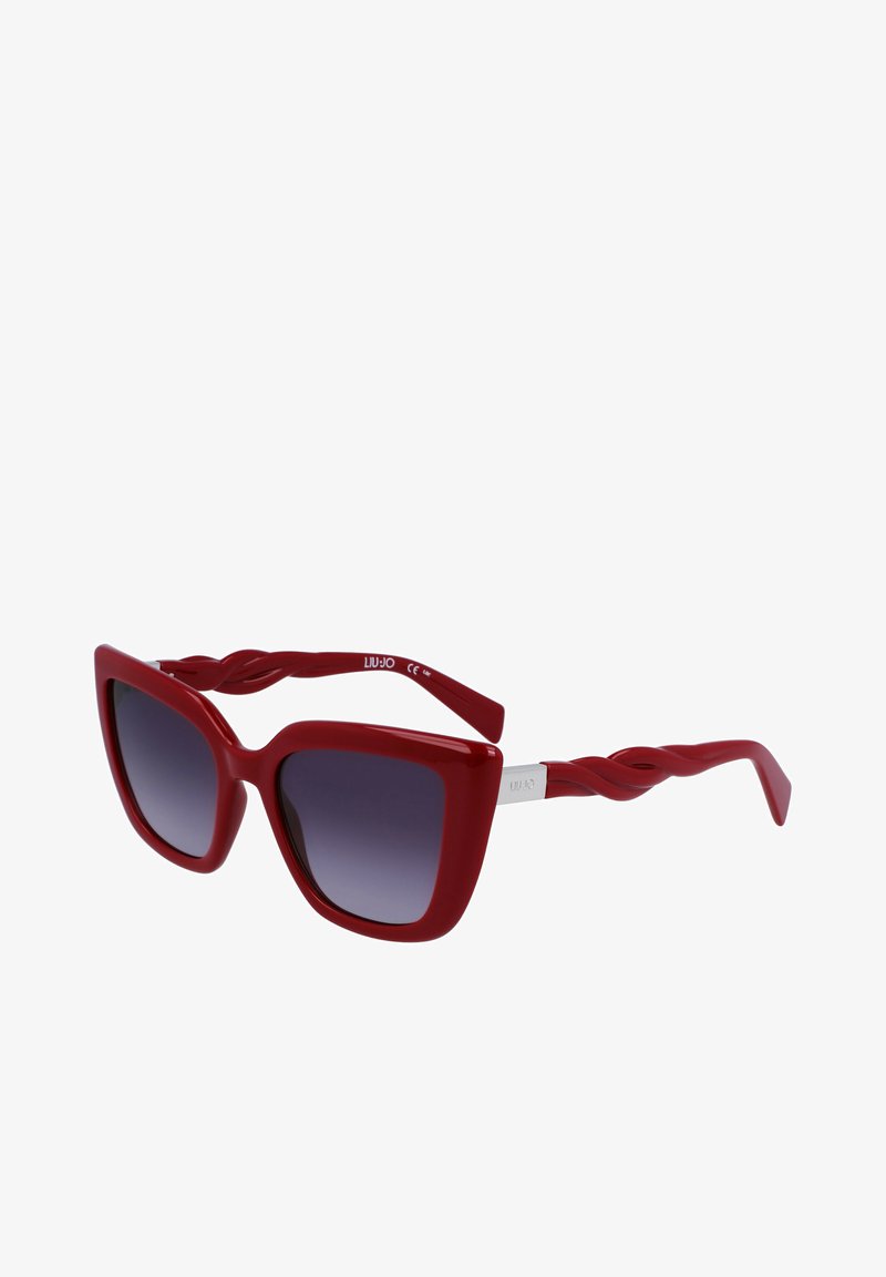 Red oversized sunglasses with a glossy finish, square frames, twisted arms, and gradient lenses. Silver hardware on the temples.
