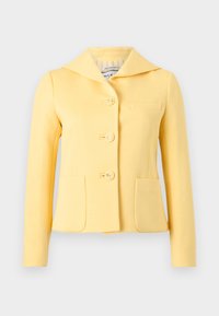 Chaqueta amarilla entallada con cuello ancho, tres botones con relieve de ancla y dos bolsillos delanteros, mostrada sobre un fondo liso.