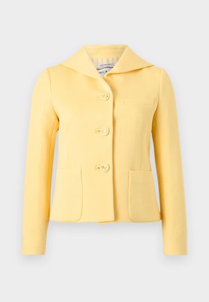 Sárga, szabott zakó széles gallérral, három horgony dombornyomott gombbal és két első zsebbel, egyszínű háttéren bemutatva.