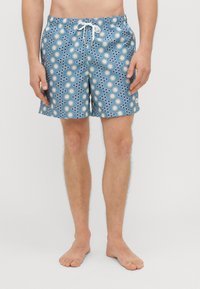 Peldbikses, kas izgatavotas no viegla auduma, ar zilu fonu, kas rotāts ar baltām ziedu un apļu rakstiem, elastīgu jostu un aukliņu.