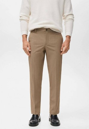 Pantalones marrones a medida en una tela suave con un diseño de pierna recta, que cuentan con un bolsillo delantero y un pliegue sutil a lo largo de cada pierna.