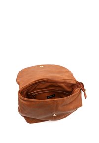 Sac en cuir brun avec une texture douce, une fermeture éclair et un détail en bouton doré. L'intérieur comprend une poche zippée et un revêtement en tissu.