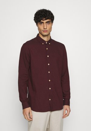 Bordåred button-up skjorte med lange ærmer, med en klassisk krage og lyse träknapper, laget av et teksturert stoff.
