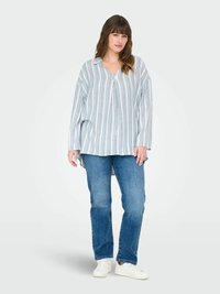 Chemise rayée à boutons en bleu clair et blanc, avec un col, des manches longues et une coupe décontractée, associée à un jean bleu et des baskets blanches.