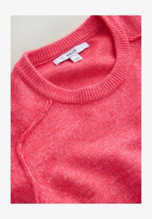 Różowy dzianinowy sweter z okrągłym dekoltem, prążkowanym kołnierzem i raglanowymi rękawami. Tekstura jest miękka, z delikatnym melanżowym wzorem. Widoczna metka marki.