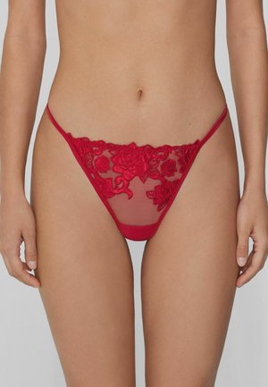 Red embroidered thong featuring a floral lace design and sheer mesh panels. The waistband is thin, enhancing its delicate appearance.