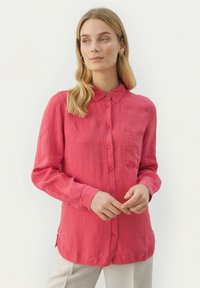 Langærmet skjorte med knaplukning i klart pink stof, med krave og enkelt brystlomme, lige søm og afslappet pasform.