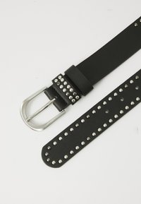 Ceinture en cuir noir avec des clous en métal argenté le long de la sangle, dotée d'une boucle en métal rectangulaire et d'une décoration par clous sur la bande en cuir.