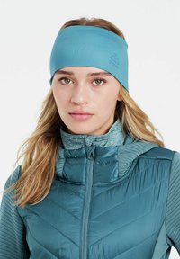 Šviesiai mėlynas galvos juostos aksesuaras, pagamintas iš tamprios medžiagos, sukurtas priglusti prie galvos. Atrodo švelniai, su subtiliu logotipu ant šono.