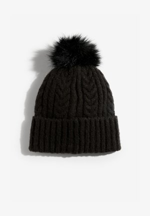 Czarna dziergana czapka z prążkowaną fakturą, z puszystym czarnym pomponem na górze. Materiał wydaje się miękki i gruby, zapewniając ciepło.