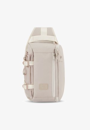 Beige Stoffrucksack mit verstellbaren Trägern, vorderer Reißverschlusstasche, seitlicher elastischer Tasche und Logo-Patch. Verfügt über eine glatte Textur und ein minimalistisches Design.