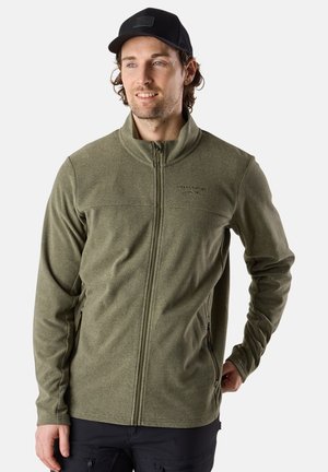 Grüne Fleecejacke mit hohem Kragen, Frontreißverschluss und Seitentaschen. Der Stoff hat eine strukturierte Oberfläche. Getragen mit einer schwarzen Mütze.
