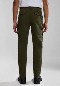 Grüne Cargo-Hosen mit geradem Schnitt, ausgestattet mit Seiten- und Gesäßtaschen, aus leichtem Stoff, kombiniert mit schwarzen Schuhen.