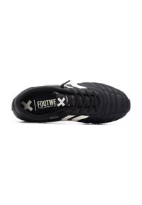 Zapatilla deportiva negra con parte superior texturizada, que presenta acentos en blanco y un diseño con cordones. El interior muestra el nombre de la marca con logotipos distintivos.