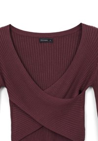 Burgunderfarbenes, geripptes Langarmoberteil mit V-Ausschnitt, das mit einem Wickeldesign und einer weichen Textur ausgestattet ist. Markenlabel im Kragen sichtbar.