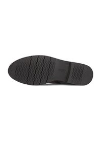 Zwarte rubberen zool met een gestructureerd zigzagpatroon, voorzien van een lichte hak en een logo-afdruk nabij het hakgebied voor grip.