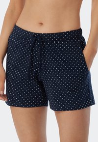 Mörkblå shorts i mjukt tyg med dragsko i midjan och vita prickar, utrustade med sidofickor och en avslappnad passform.